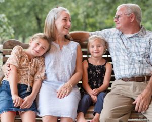 Candid family moment on outdoor bench during summer day.
