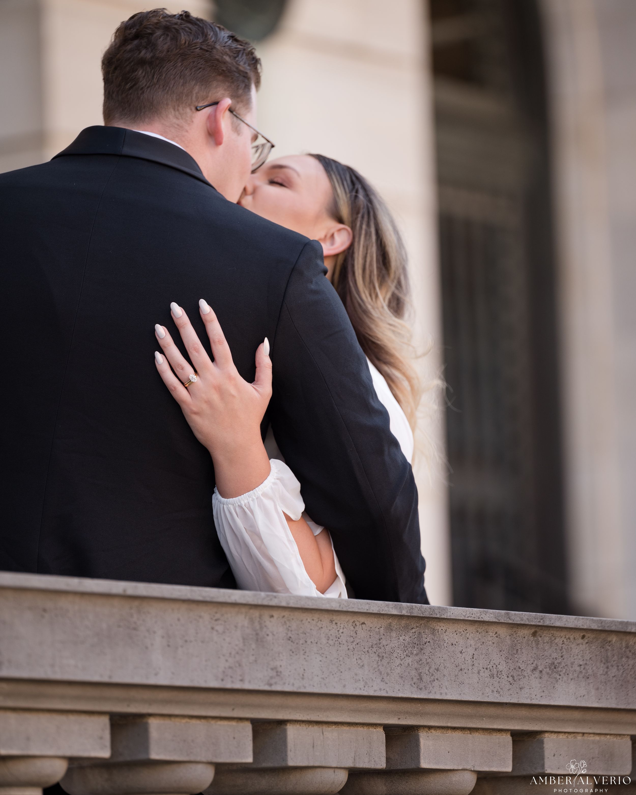 A romantic embrace between a couple on a stone balcony as they share a tender moment together.
