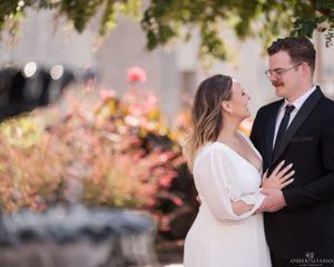 A romantic couple shares a tender moment outdoors with soft bokeh lights and autumn foliage in the background.
