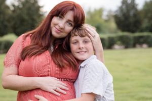 A heartwarming outdoor portrait shows two people embracing in a peaceful garden setting.