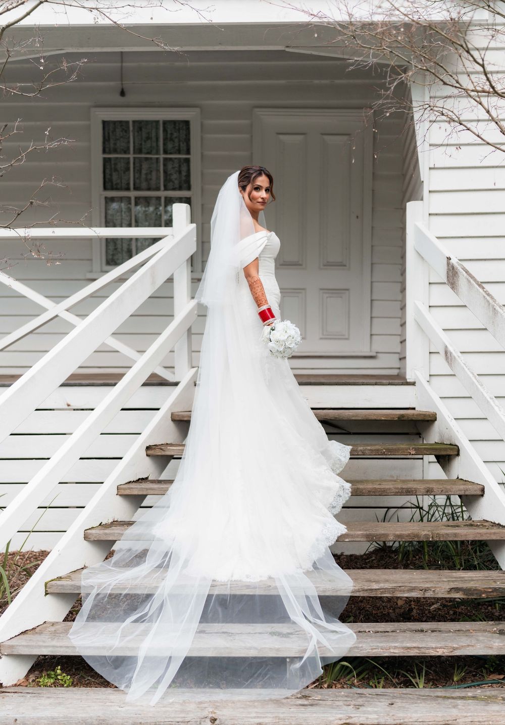 A flowing white wedding veil gracefully moves across a rustic wooden porch in a series of progressive motion shots.
