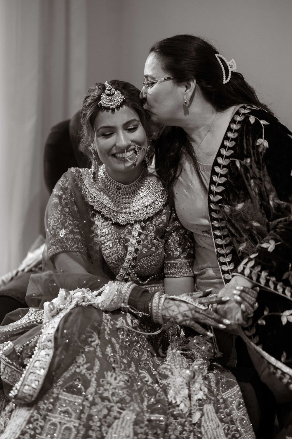 A sequence of candid moments showing people in traditional Indian wedding attire sharing joyful laughter together.