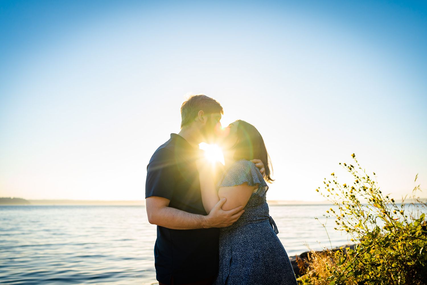 Husband and wife kiss at Lincoln Park in Seattle.