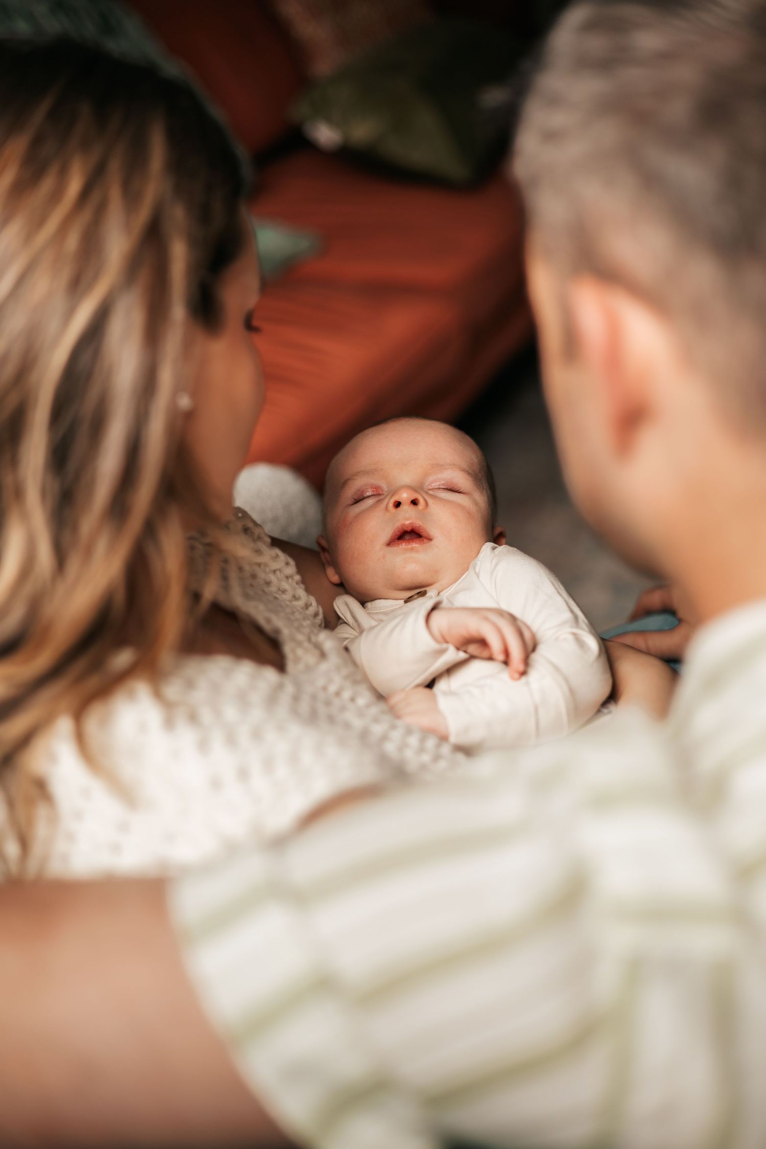 Two parents lovingly gaze at their sleeping newborn baby  | Newborn Photographer in Broomfield Colorado