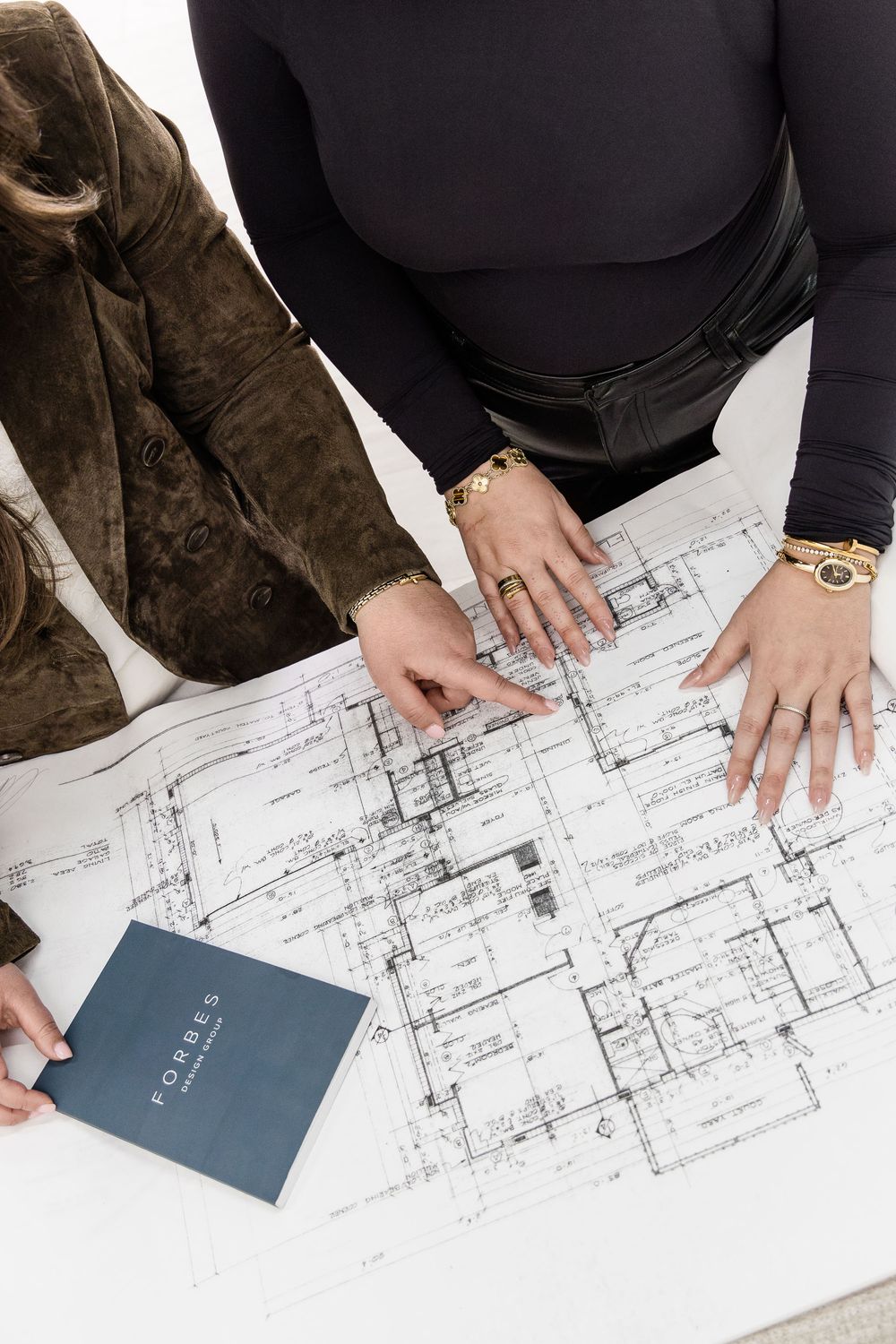 Interior designers analyzing architectural floor plans during a luxury residential design consultation in Jupiter, Florida.
