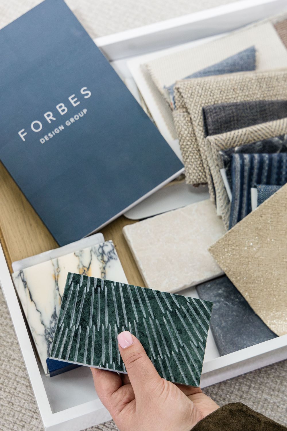 Close-up of luxury interior design material samples including fabric swatches, stone, and tile selections in Jupiter, Florida.