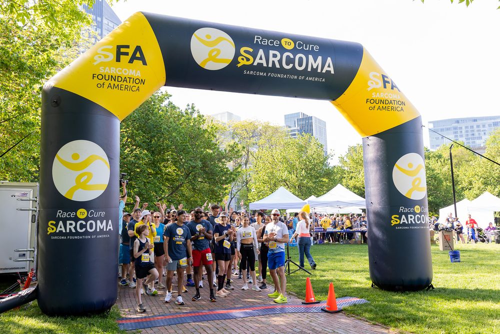 Runners cross the finish line at the Race to Cure Sarcoma charity event hosted by the Sarcoma Foundation of America.