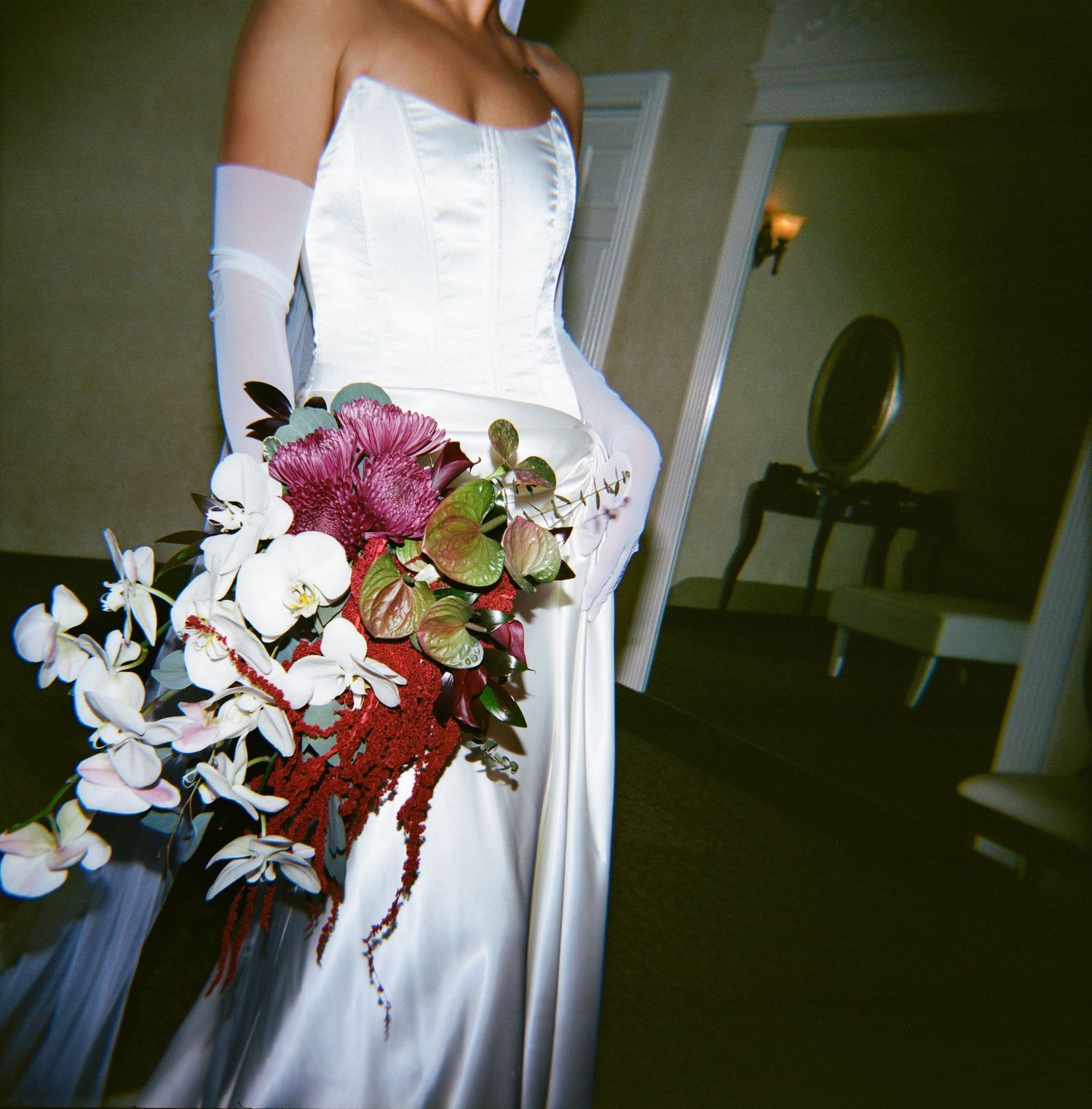 Black and white aerial view of bride and groom ascending elegant staircase with ornate wooden banister.