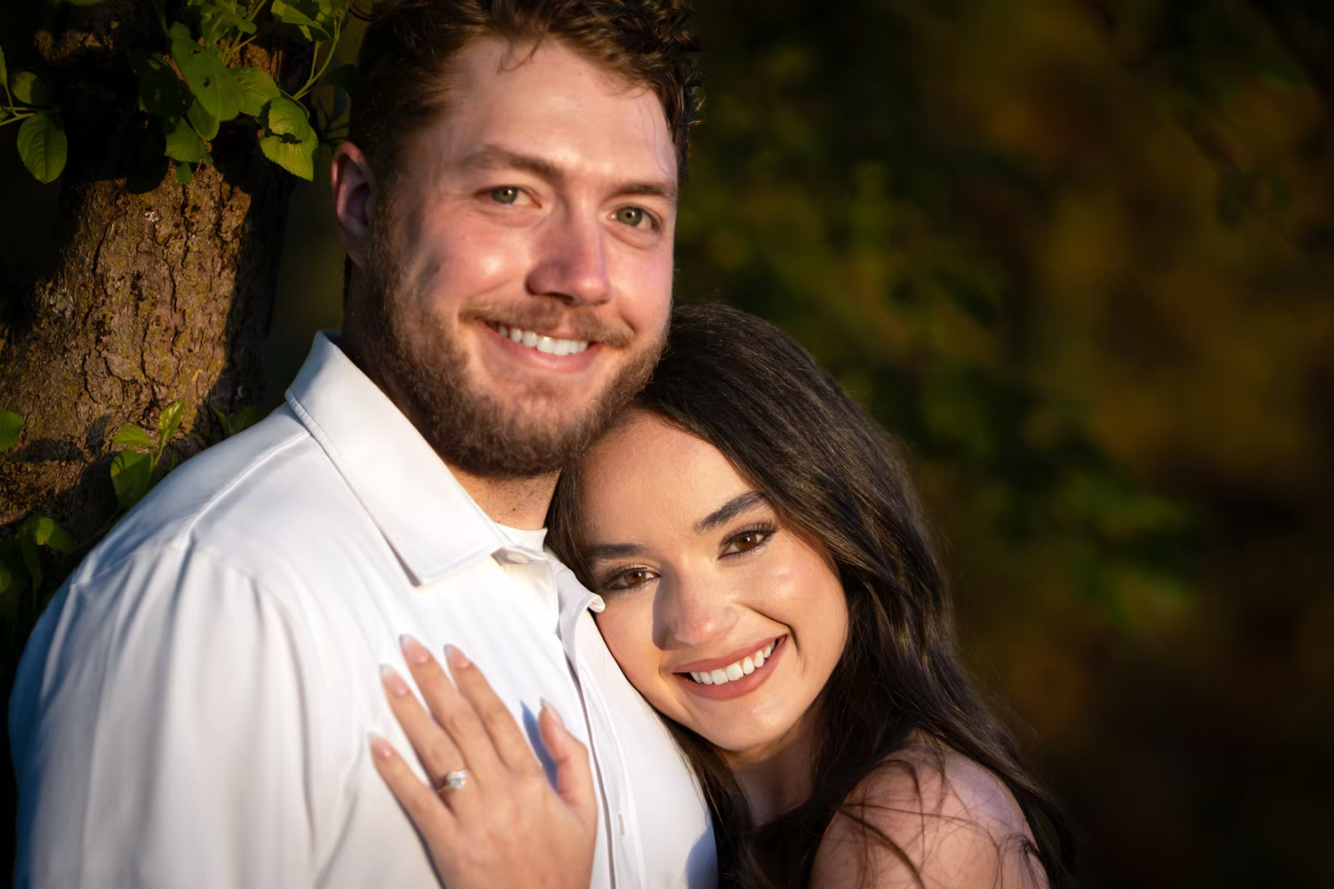 Smiling couple posing outdoors near a tree in Franklin Park for Engagement