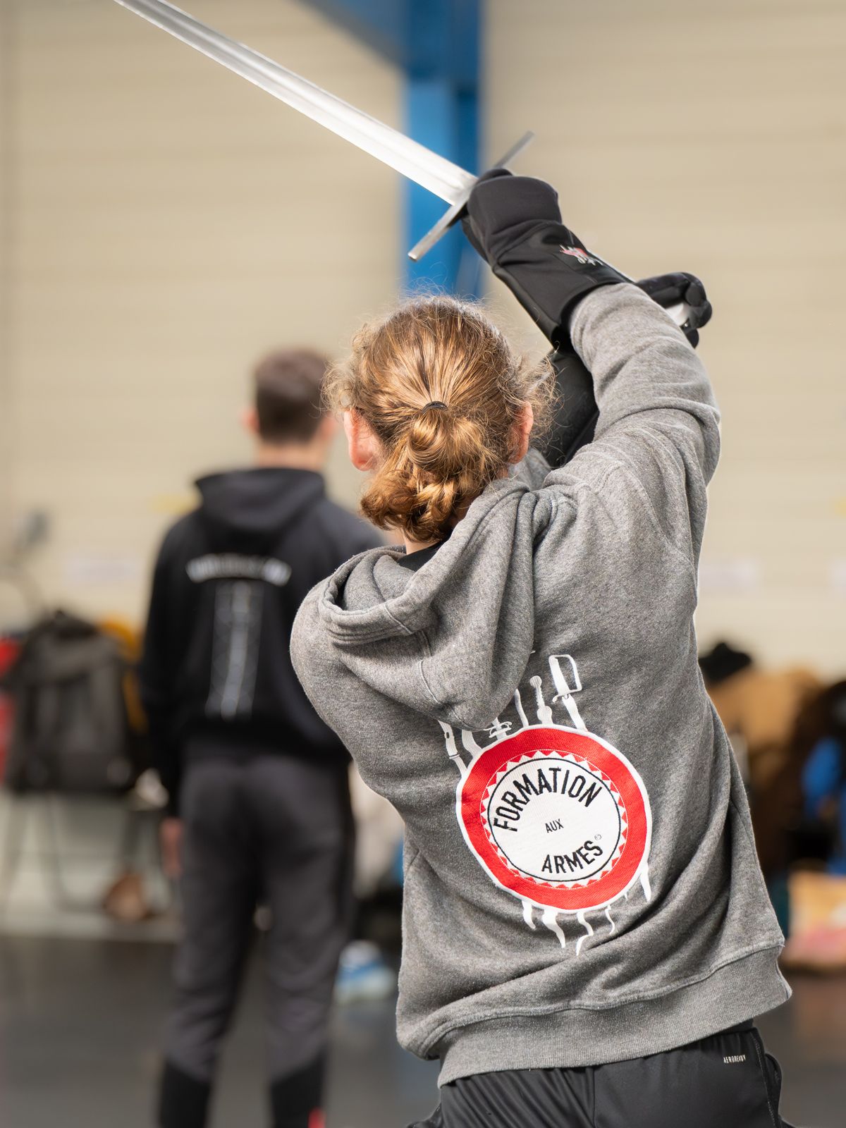 Un étudiant brandissant une épée lors d'un cours d'entraînement aux arts martiaux « Formation aux Armes ».