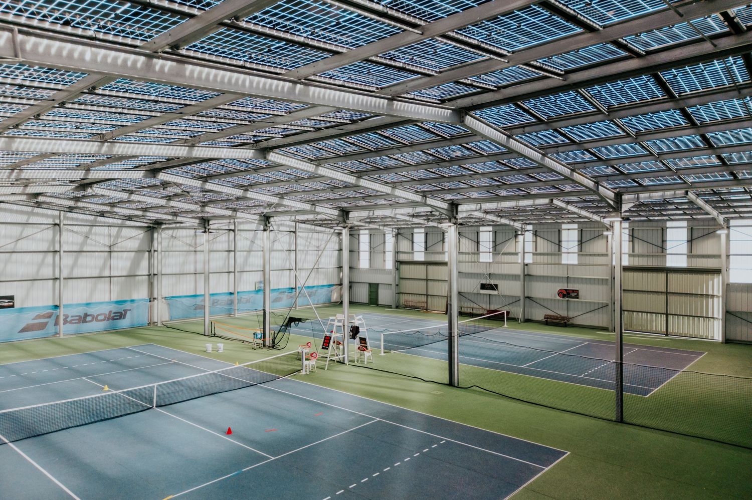 Photographe industriel à Toulouse. Terrain de tennis abrité par des panneaux photovoltaïques créant de l’ombre pour les joueurs.