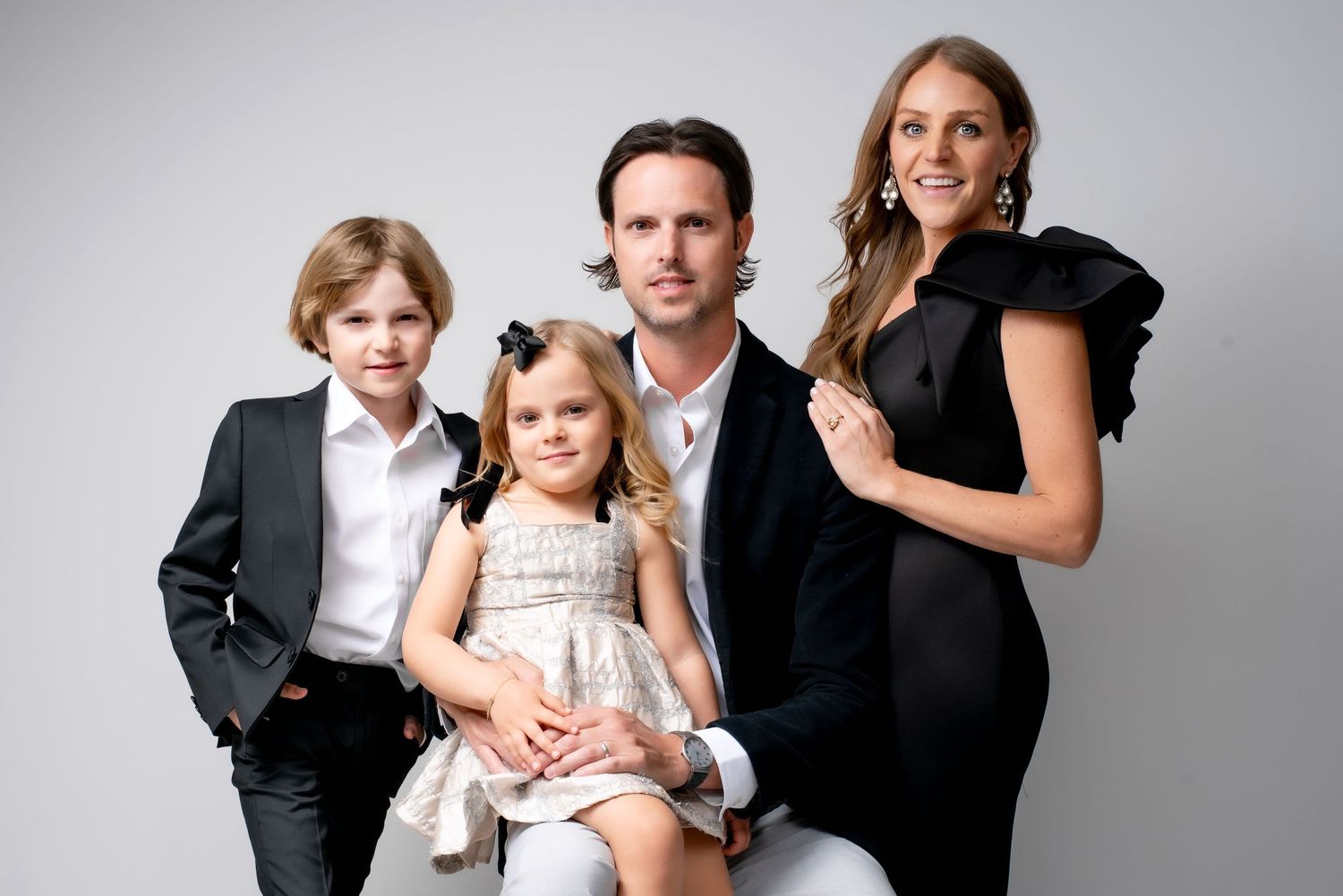 Elegant family portrait in Nashville studio with parents and two children dressed in formal outfits, timeless luxury family photography
