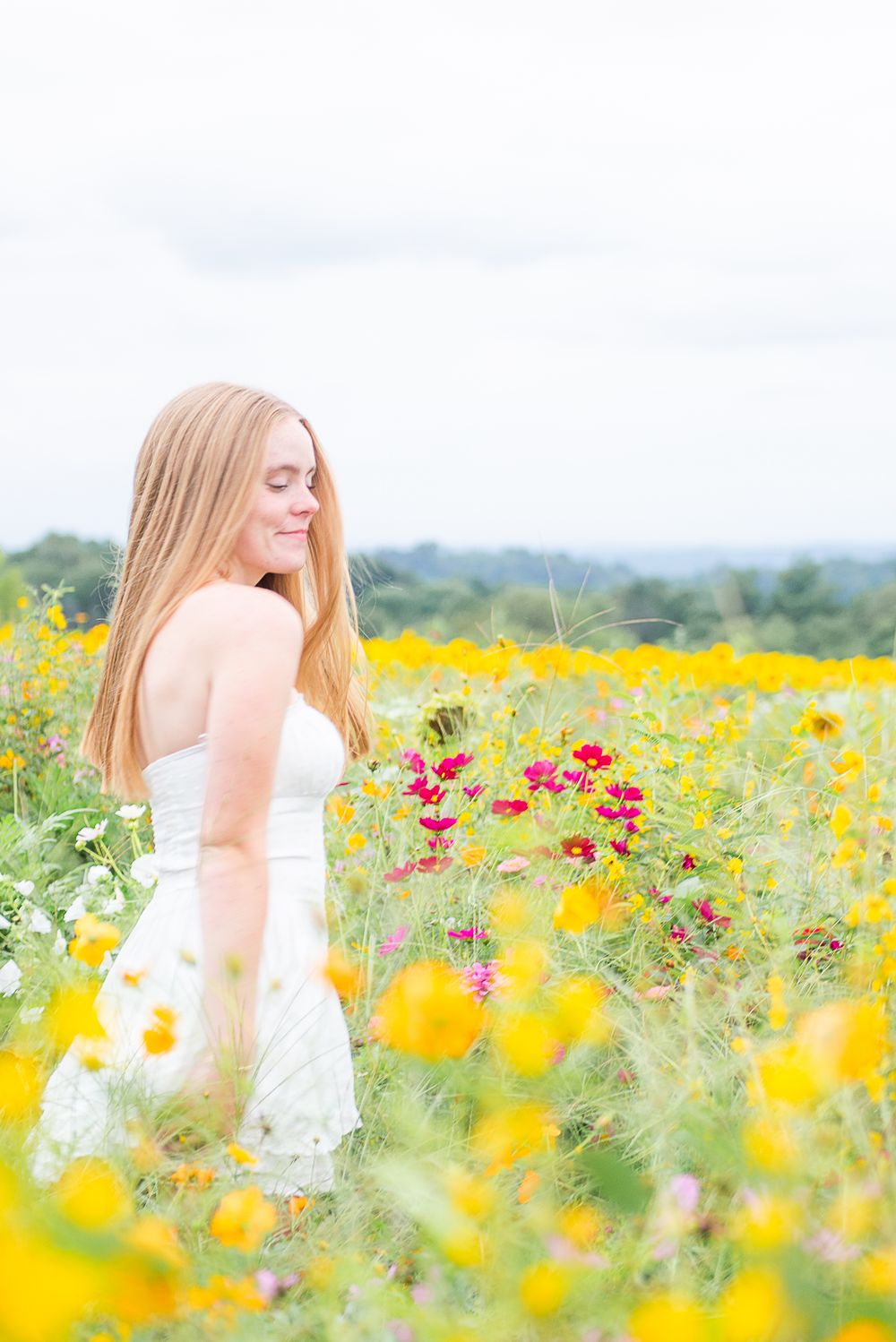 A dreamy portrait series in a vibrant wildflower meadow filled with yellow and pink blooms on a bright summer day.