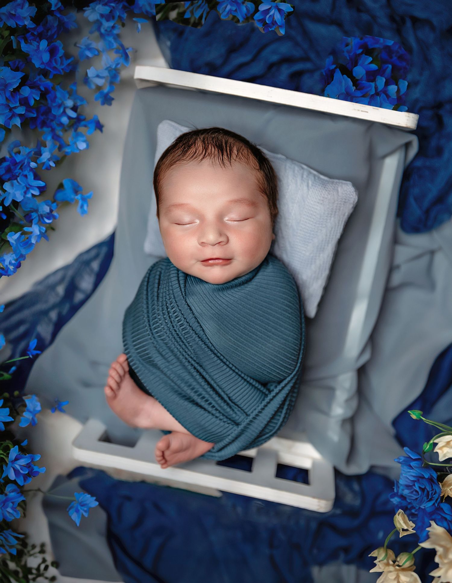 newborn baby boy captured in a beautiful set up with blue florals in northwest fresno studio colibri captures