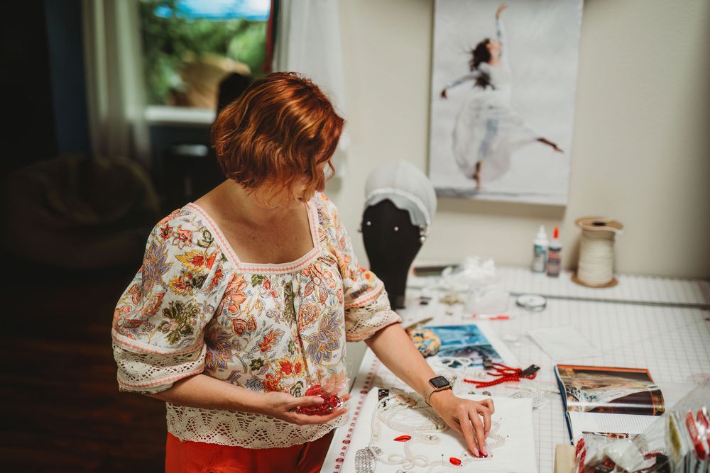 Creative workspace with floral-patterned clothing visible as someone works on an art project.