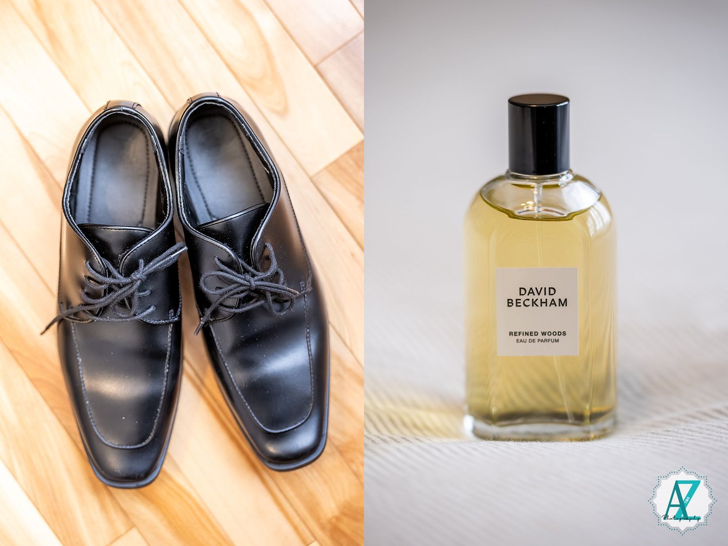 Black leather loafers with bow detail on wooden floor next to perfume bottle.