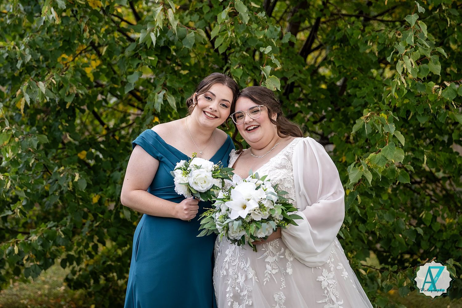 Wedding couple shares intimate moments in front of lush green foliage during outdoor photo session.