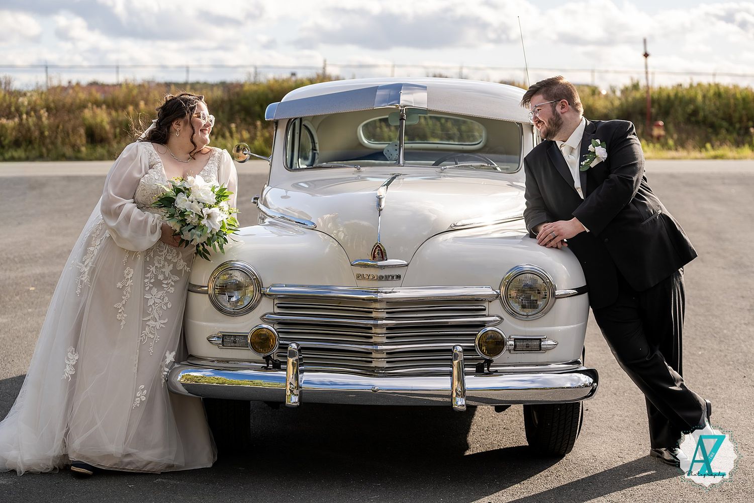 Classic silver vintage car featured in romantic wedding photography session against outdoor backdrop.