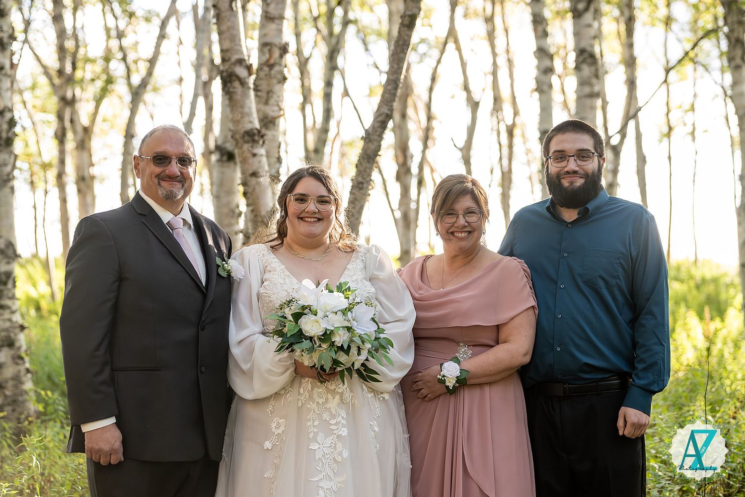 Wedding party poses together in a beautiful aspen grove during golden hour.