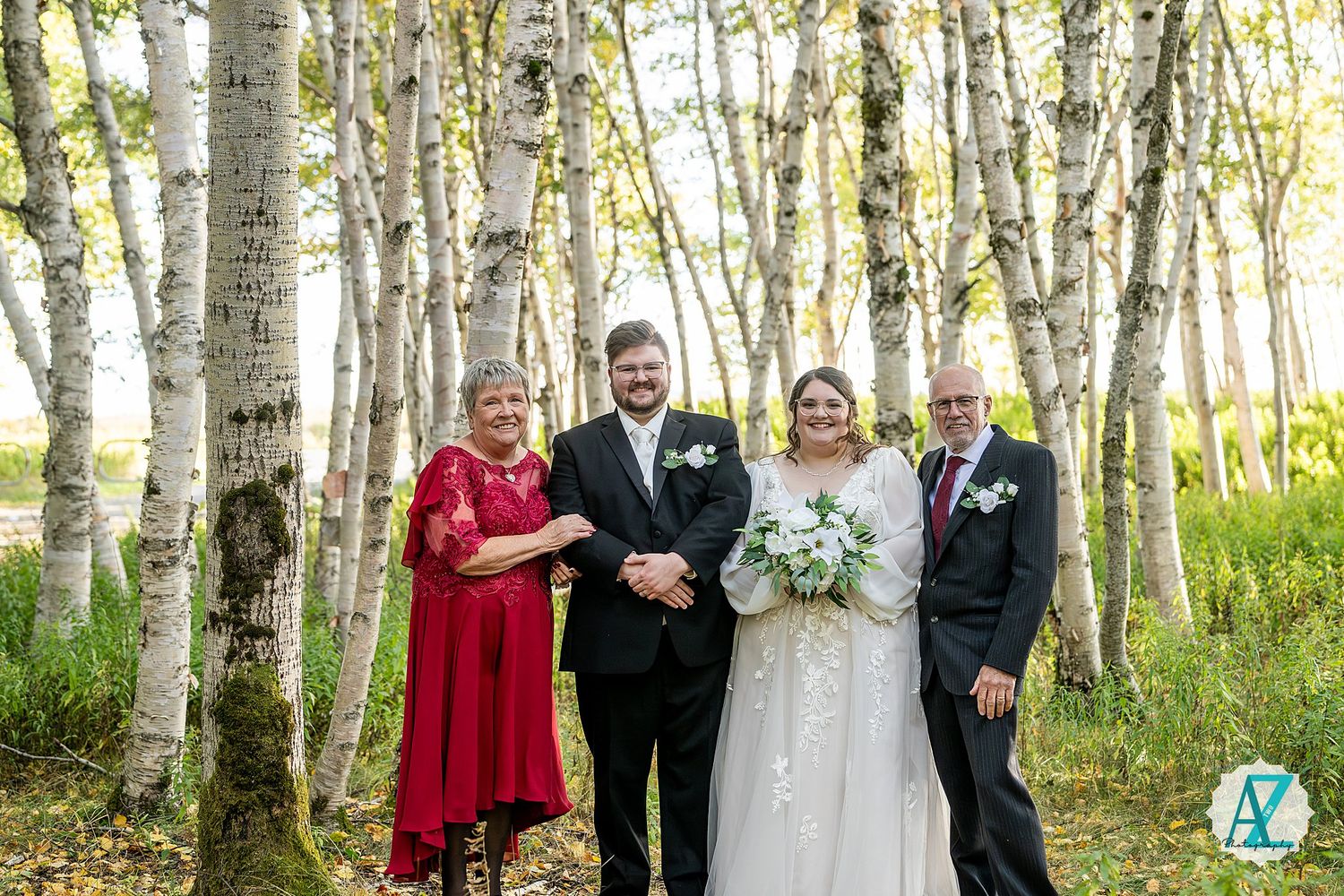 Wedding group portraits taken among white birch trees in an enchanted forest setting.