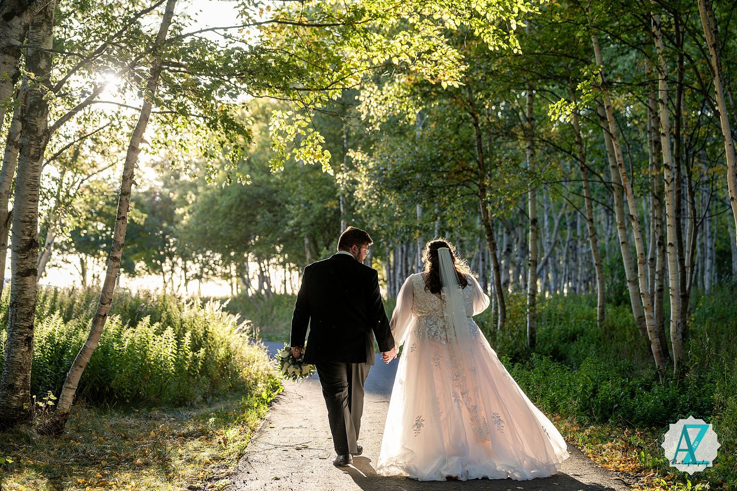 Romantic wedding photography session in a sunlit aspen grove with natural woodland backdrop.
