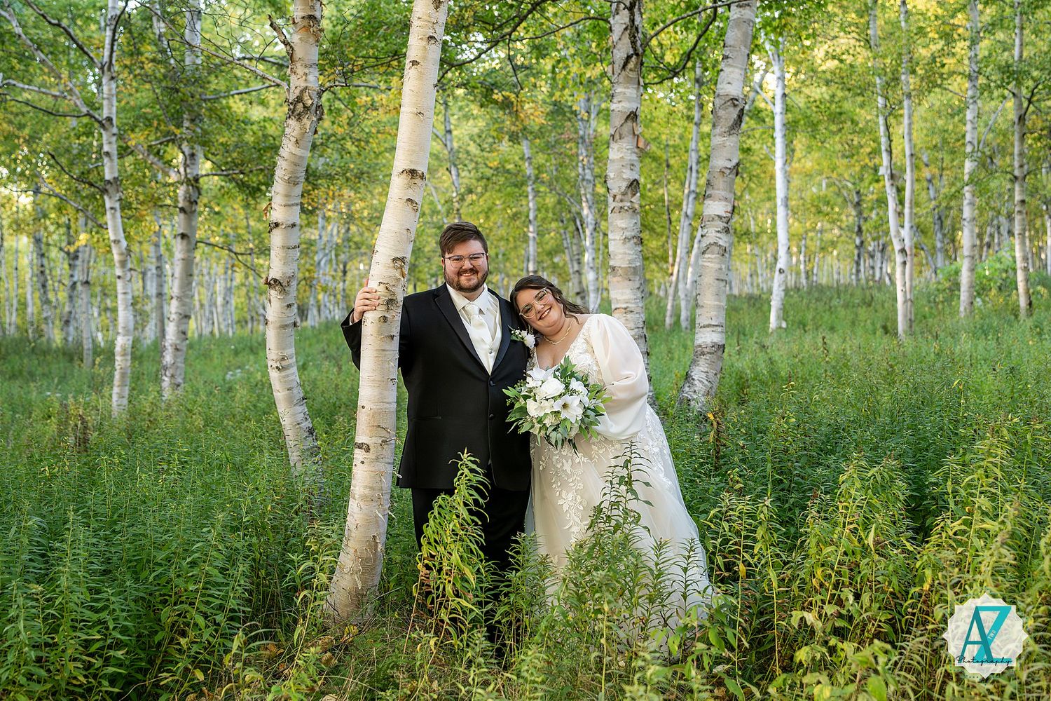 Elegant wedding portraits captured in a serene birch forest with soft natural lighting.