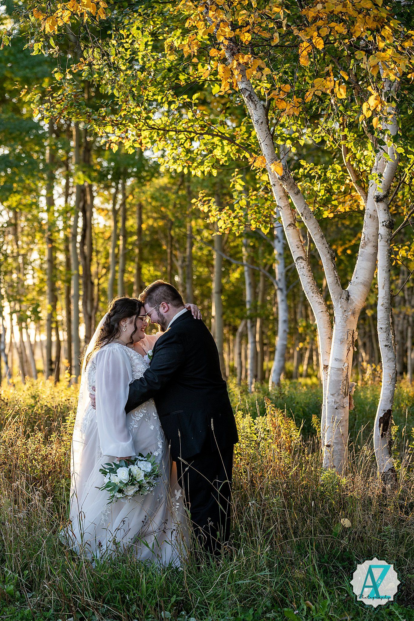 Golden autumn light filters through birch trees during an intimate wedding photo session.