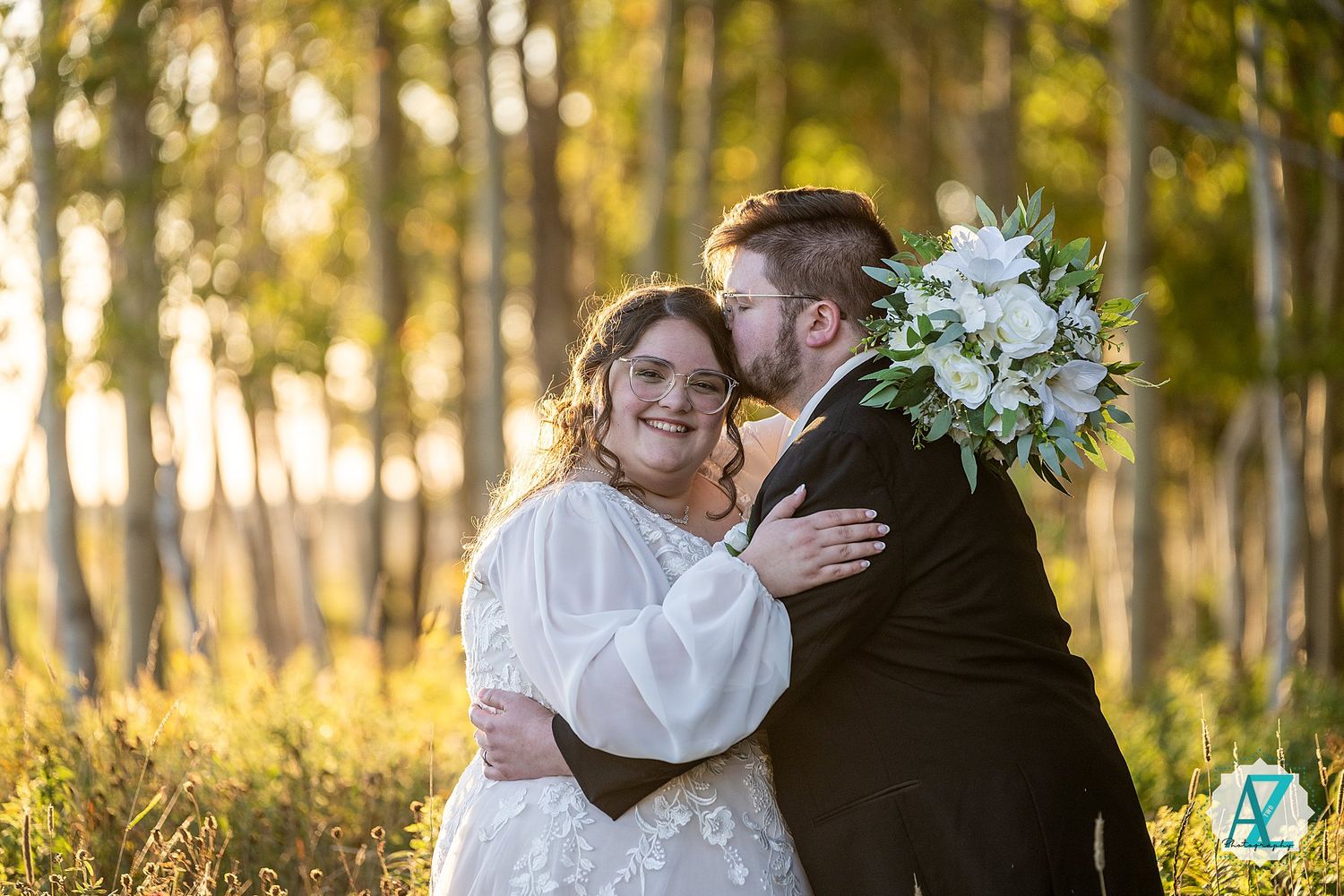 Wedding couple shares intimate moments in a sunlit forest with white birch trees.