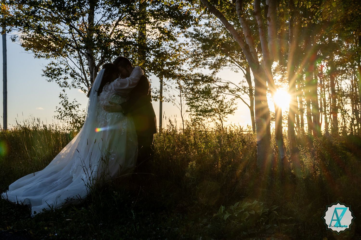 A romantic sunset silhouette of a couple in a wedding dress and suit standing among trees in a forest.