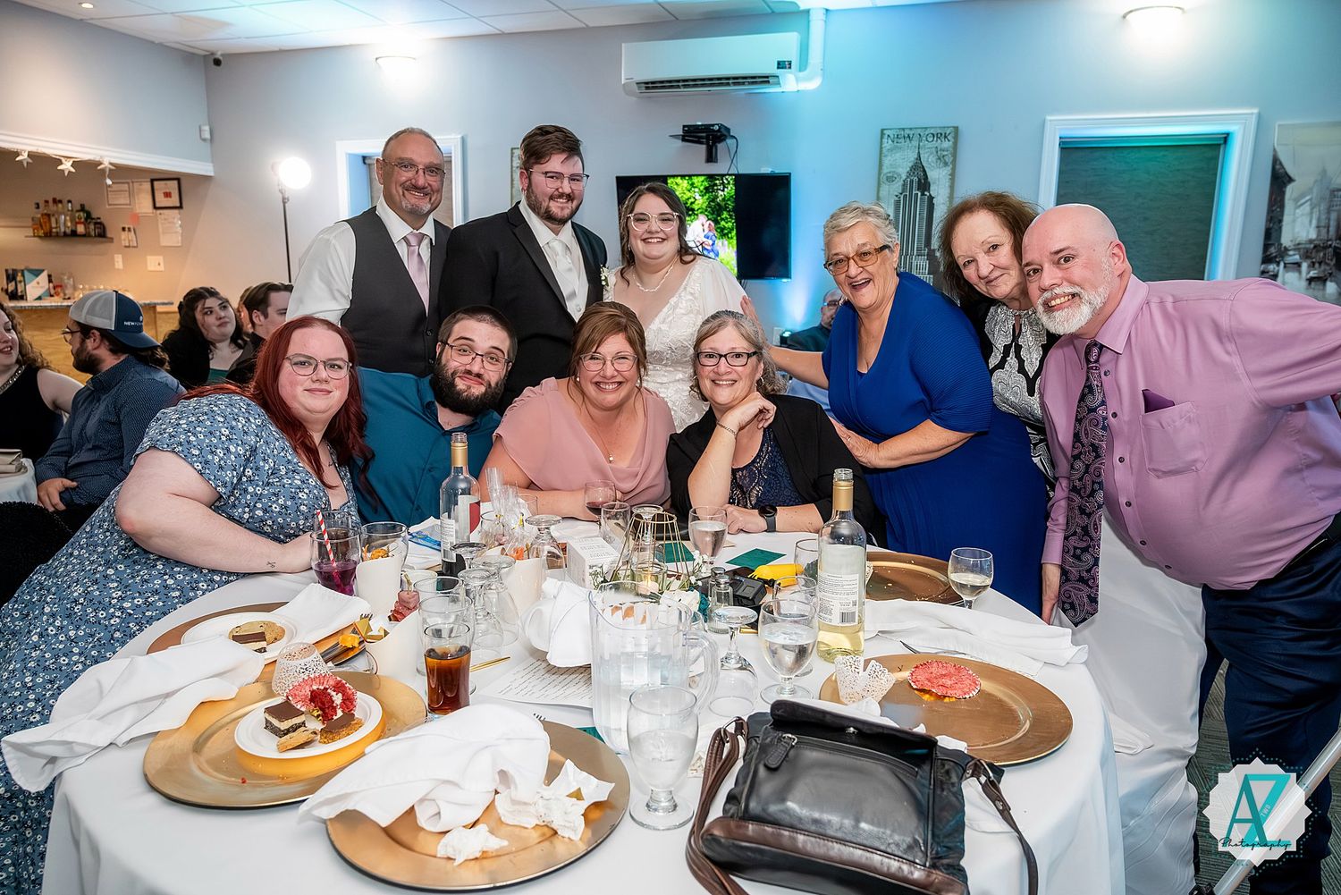 Reception guests gathered around tables sharing meals and laughter at wedding celebration.