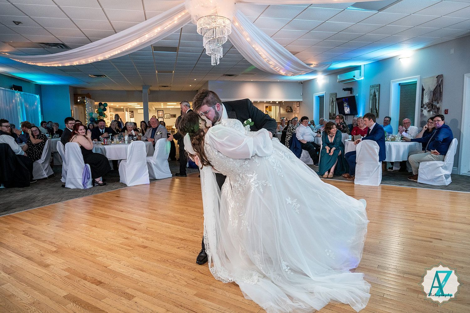 Wedding reception dance floor with elegant draping and chandelier lighting.