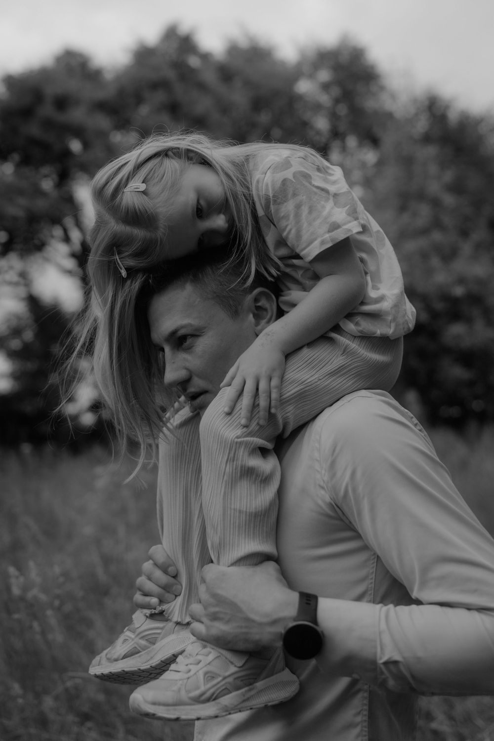 Black and white photo of a couple embracing in an outdoor setting.