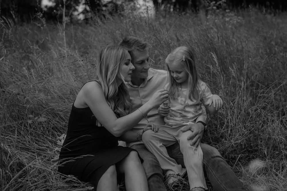 Black and white candid moments of a family playing in nature.