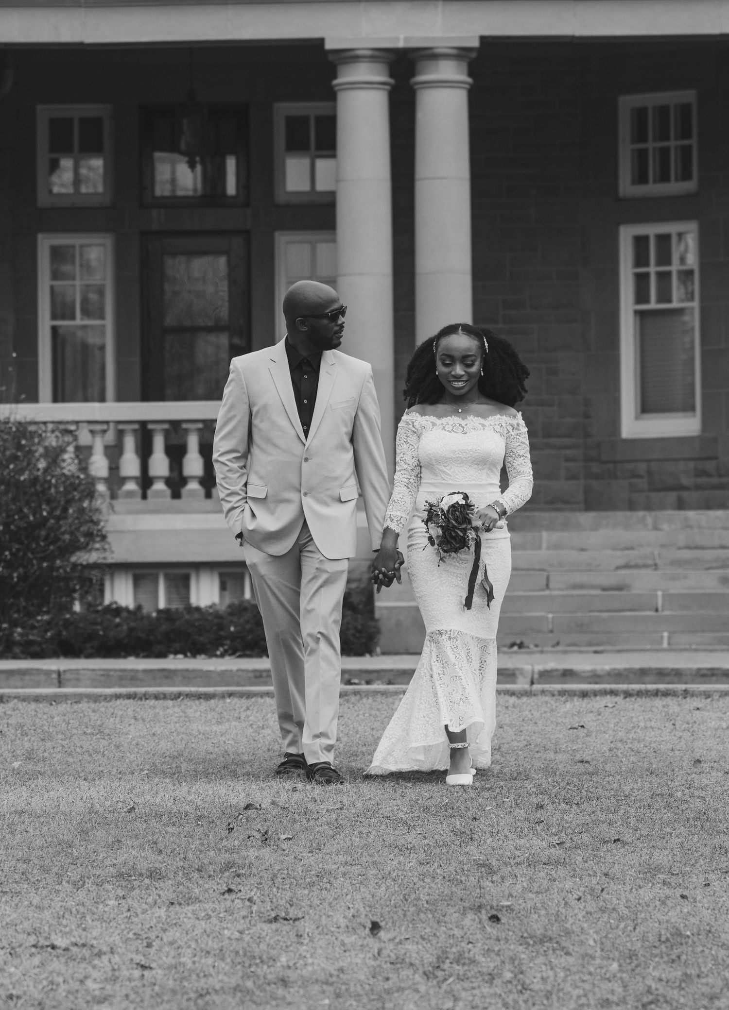 Black and white landscape wedding photos of couple outside historic building.