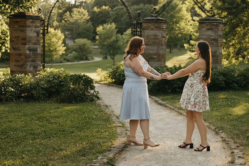 Group walking along a stone path in a sunlit garden setting wearing light summer attire in Waterloo Park
