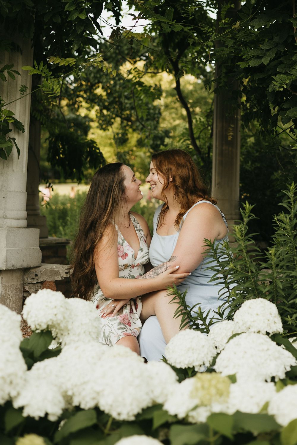 A romantic outdoor photoshoot in a garden gazebo surrounded by lush greenery and white hydrangea flowers in Waterloo Park