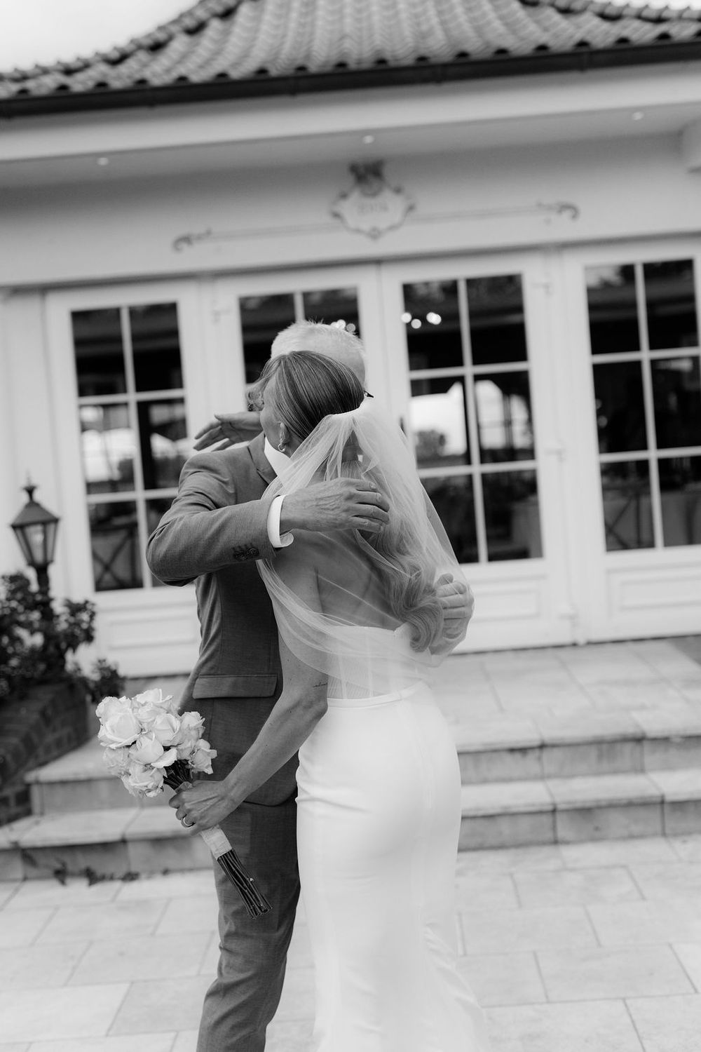 A romantic black and white wedding dance sequence showing a couple swaying together on an outdoor terrace.