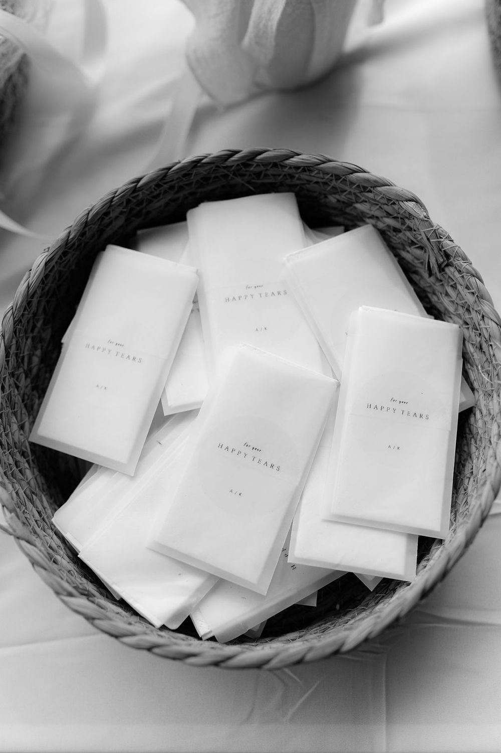A sequence of black and white photos showing white envelopes arranged in a woven basket.