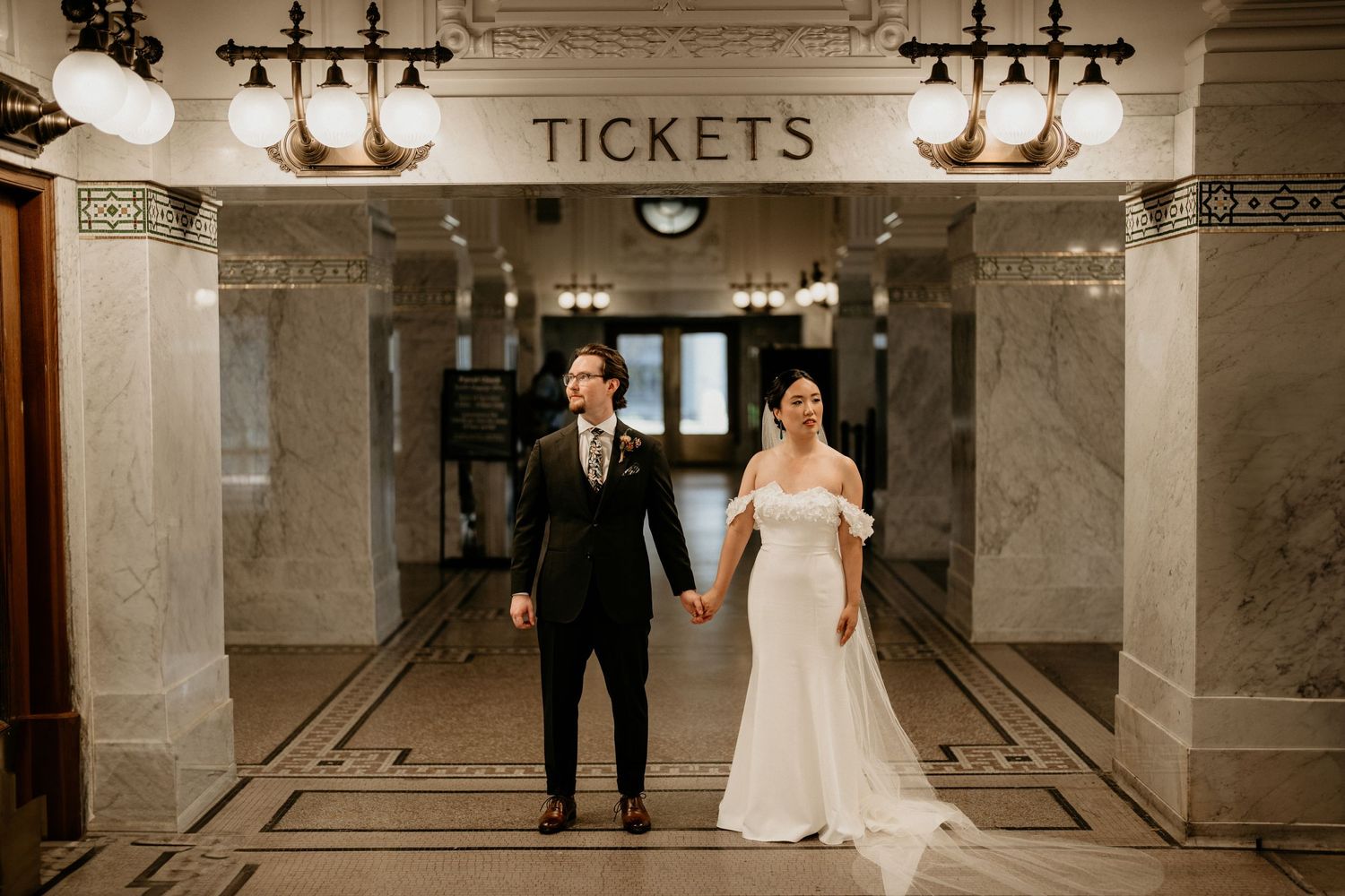 Bridge and Groom standing at Seattle Train station as they pose together.