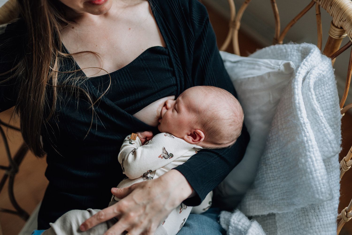 En nyfödd bebis ammas av sin mamma.