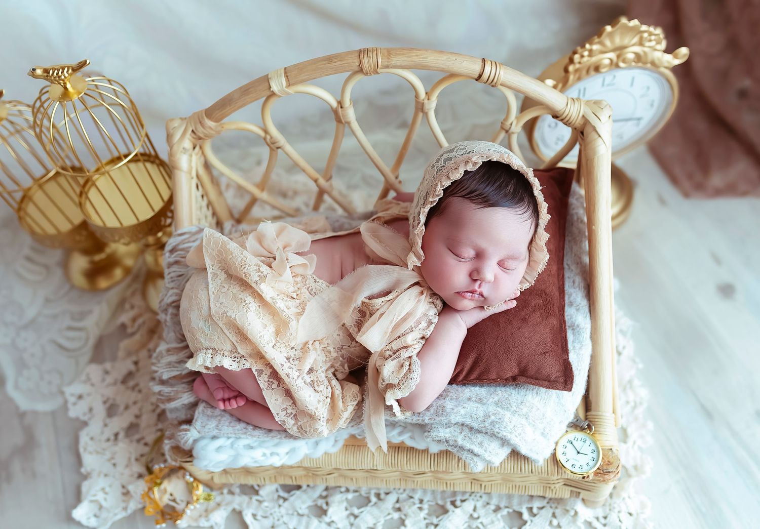 bebe recien nacida durmiendo en una camita de rattan tiene un trajecito de lace puesto