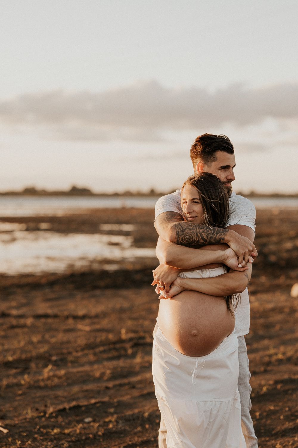 Futurs parents enlacés, partageant un moment doux et authentique