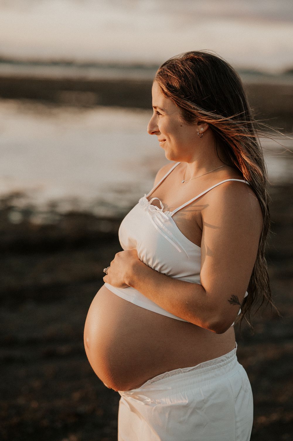 Future maman en lumière naturelle, captée dans un moment doux et authentique