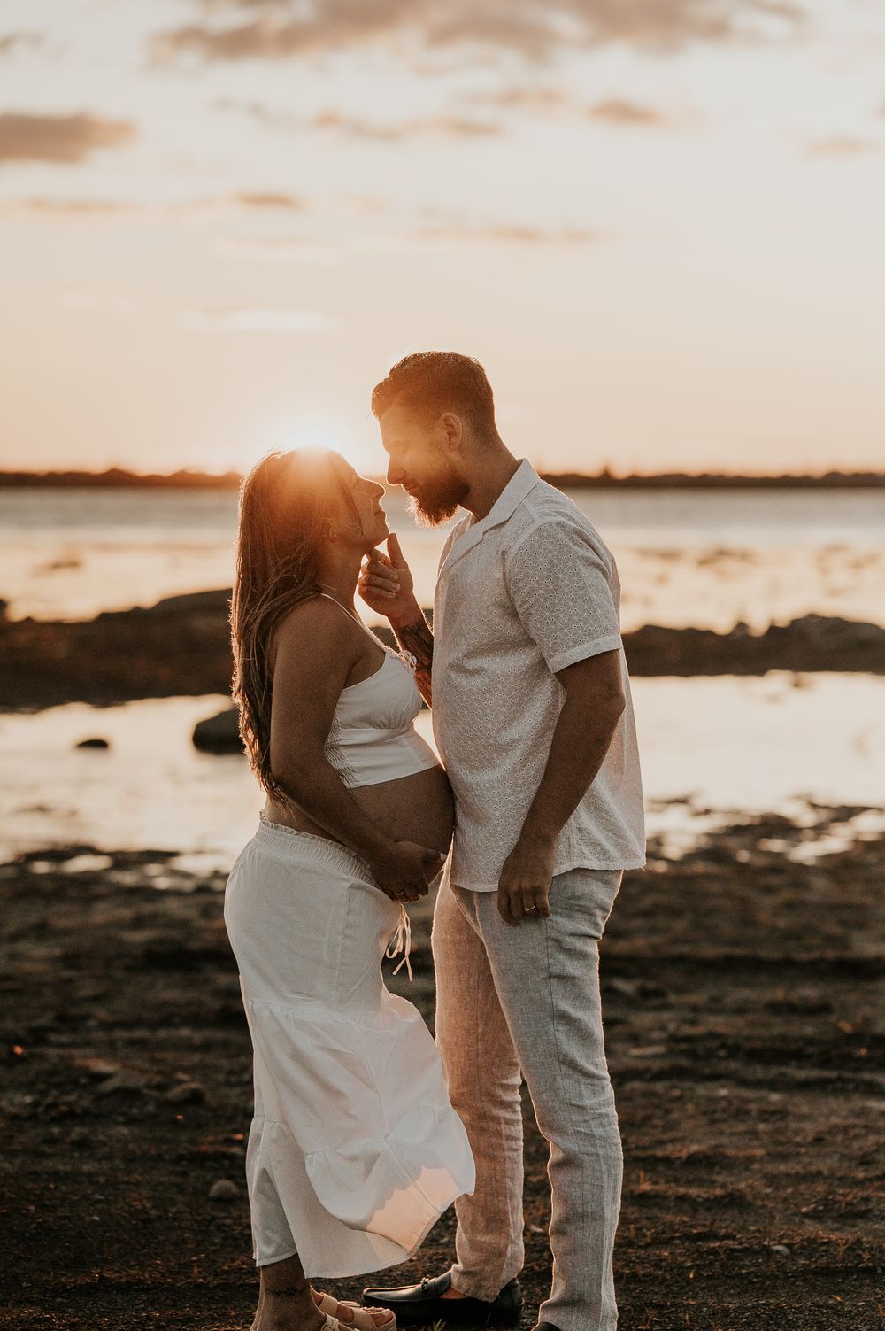 Couple attendant un bébé, capté dans un moment tendre en lumière naturelle
