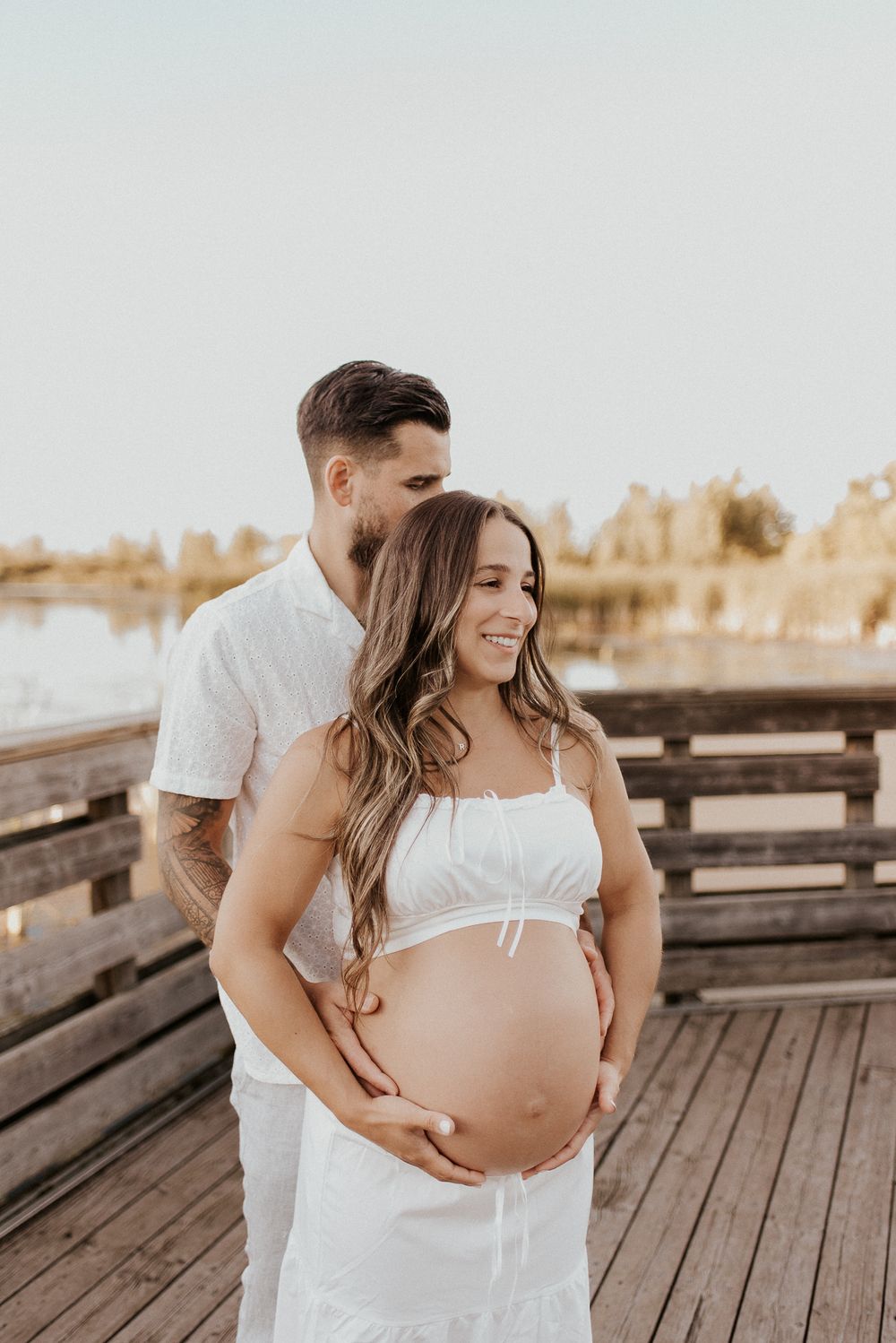 Couple attendant un bébé, capté dans un moment tendre en lumière naturelle