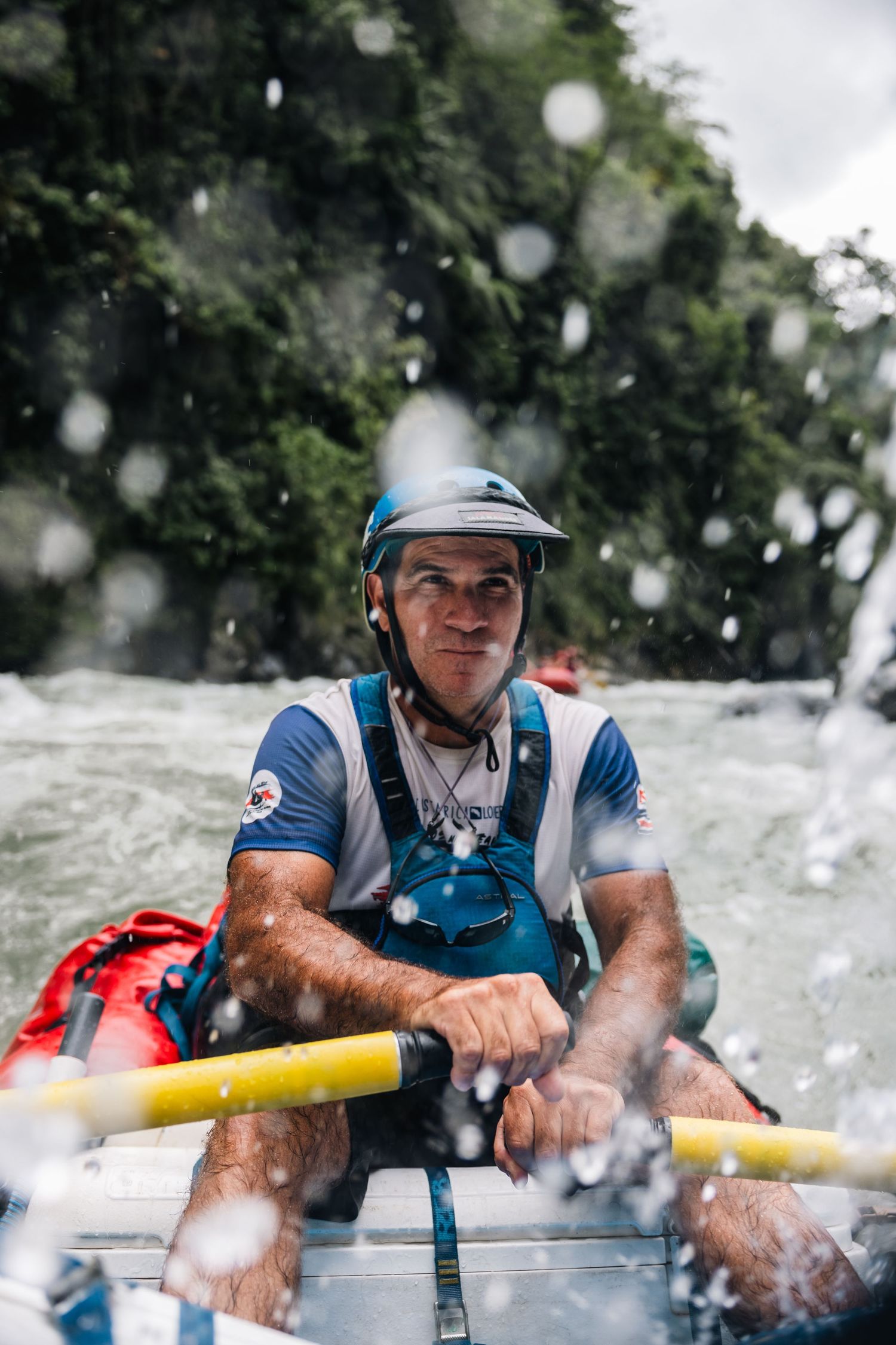 A whitewater rafter navigating through splashing rapids on a river.