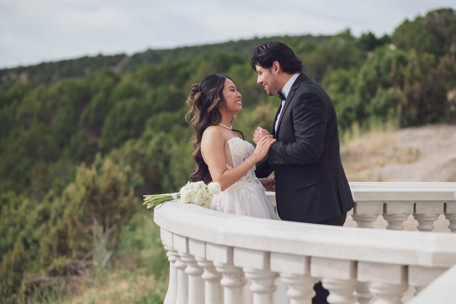 Romantic wedding portrait of couple on a castle balcony.