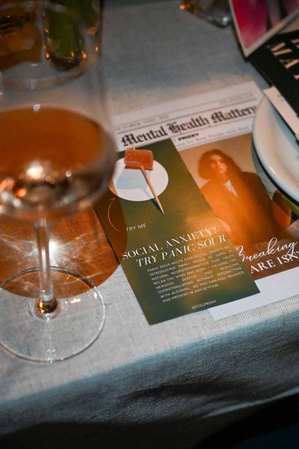Close-up shots of wine glasses and menu cards on a white tablecloth in warm ambient lighting.