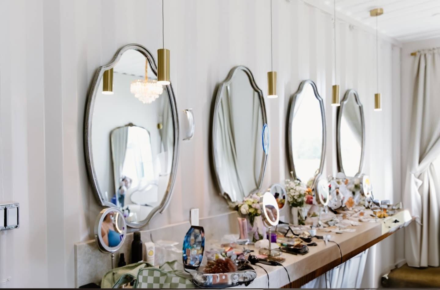 Bridal preparation room with elegant gold mirrors and vanity lighting.