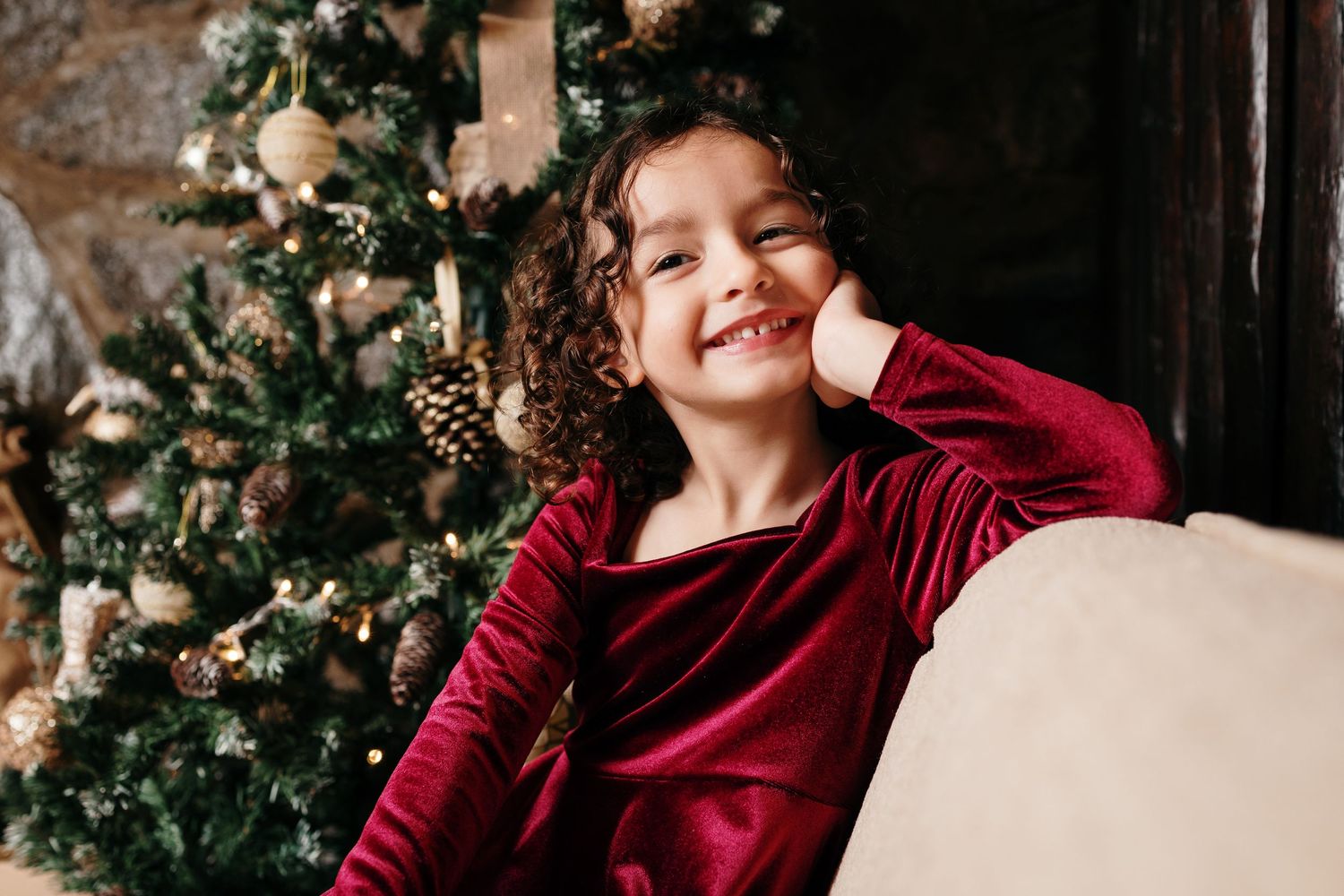 Family wearing burgundy outfits posing together for holiday portraits.